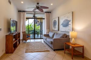 un soggiorno con un divano e un ventilatore a soffitto di Sunrise 42 - 2 Bedroom Ocean View Condo a Tamarindo