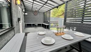 a table with plates and wine glasses on a patio at MODERN SUITES -5 Bedroom House- With FREE PARKING Birmingham city in Birmingham
