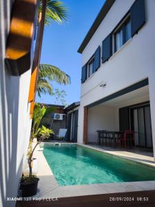 a villa with a swimming pool next to a house at VILLA O'LHAYA piscine pivée in Saint-Joseph