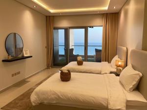a hotel room with two beds and a large window at Damac Tower Jeddah apartment in Jeddah +32 photos