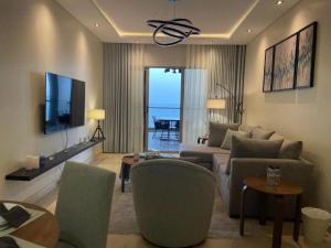 a living room with a couch and a tv at Damac Tower Jeddah apartment in Jeddah