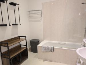 a white bathroom with a tub and a sink at 2 Chapel Nazareth in Penrhyndeudreath