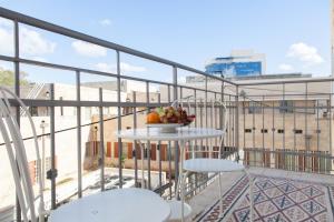 un plato de fruta en una mesa en un balcón en Carmel Apartments, en Haifa