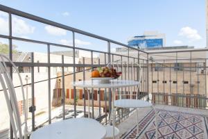 a bowl of fruit on a table on a balcony at Carmel Apartments in Haifa