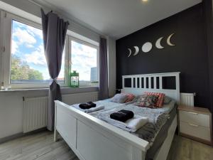 Un dormitorio con una cama blanca y una ventana grande. en Apartamenty Parkowe nr 10, en Kwidzyn