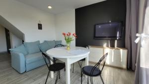 Una sala de estar con una mesa y un sofá azul. en Apartamenty Parkowe nr 10, en Kwidzyn