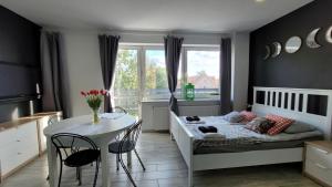 Un dormitorio con una cama y una mesa y una ventana. en Apartamenty Parkowe nr 10, en Kwidzyn 5 fotos más