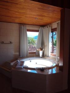 a large bath tub in a bathroom with a window at Pousada Mon Desir in Penedo +78 photos