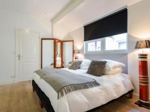 a bedroom with a large white bed with a large window at Palm Apartment Amsterdam in Amsterdam