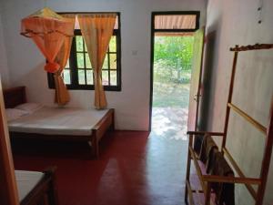 Habitación con cama, ventana y puerta en Gami Gedara Homestay, en Polonnaruwa