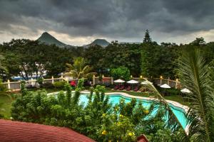 un complejo con piscina y montañas de fondo en The Gateway Hotel Ambad, en Nashik