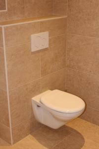 a bathroom with a toilet in a tiled wall at Ferienwohnungen Falch Simone in Sankt Anton am Arlberg