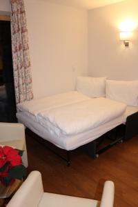 ザンクト・アントン・アム・アールベルクにあるFerienwohnungen Falch Simoneのソファ付きの客室の白いベッド1台