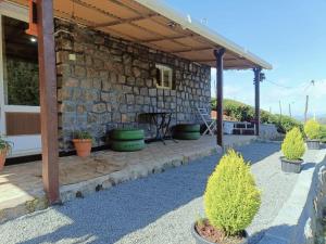 a stone house with a patio with potted plants at Wild and Free Farm Stay in Ooty