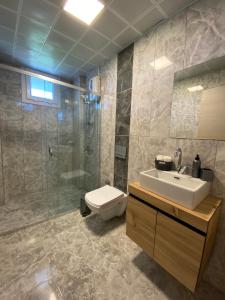 a bathroom with a sink and a shower and a toilet at Dalaman Çınar Apart in Dalaman