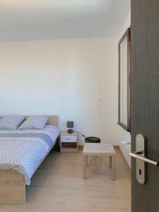 una camera da letto bianca con un letto e un tavolo di ---The Century---Au Centre d'Annecy ad Annecy