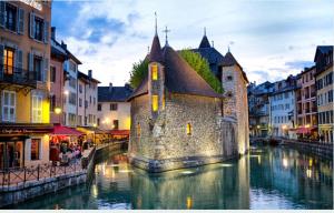 un edificio su un fiume in una città di ---The Century---Au Centre d'Annecy ad Annecy