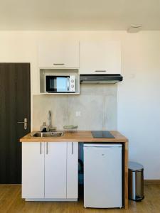 una cucina con mobili bianchi e un lavandino di ---The Century---Au Centre d'Annecy ad Annecy