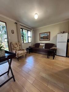 a living room with a couch and a refrigerator at Khaled Estate Cottages - unit A in Hillcrest
