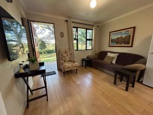 a living room with a couch and a table at Khaled Estate Cottages - unit A in Hillcrest