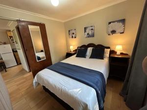 a bedroom with a large bed with two pillows at Khaled Estate Cottages - unit A in Hillcrest