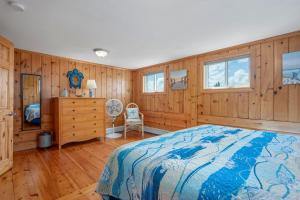a bedroom with wood paneling and a bed and windows at 215 Phillips Road Sagamore Beach - Cape Cod in Sagamore Beach