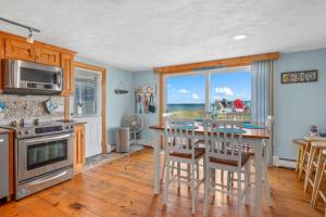 a kitchen with a table and a view of the ocean at 215 Phillips Road Sagamore Beach - Cape Cod in Sagamore Beach