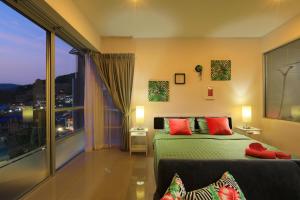 a bedroom with a bed and a large window at 1bdr Apartment with bath in Chic Condo By Capital Pro in Phuket Town