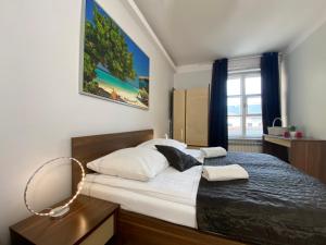 sypialnia z dużym łóżkiem z białymi prześcieradłami w obiekcie Apartments Legendary Kraków w Krakowie