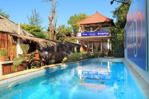 a large blue swimming pool in front of a building at Mango Dive & Bungalow in Gili Trawangan