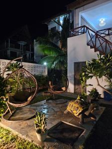 a patio with chairs and a fireplace at night at Zanzicrown in Nungwi