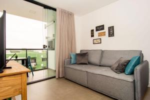 ein Wohnzimmer mit einer Couch und einem Fenster in der Unterkunft Ótima localização, Apto NOVO no Bay Village KQ8551 in Balneário Camboriú