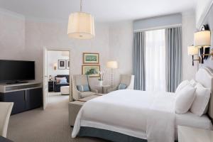 a bedroom with a large white bed and a living room at Hotel Bristol, A Luxury Collection Hotel, Warsaw in Warsaw