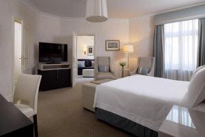 a hotel room with a bed and a living room at Hotel Bristol, A Luxury Collection Hotel, Warsaw in Warsaw