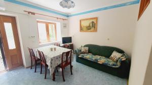 ein Wohnzimmer mit einem Tisch und einer grünen Couch in der Unterkunft Moj Mir in Betina