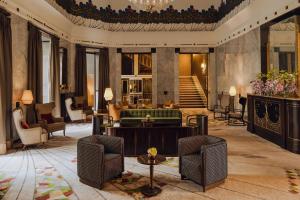 a lobby with a green couch and chairs at Hotel Bristol, A Luxury Collection Hotel, Warsaw in Warsaw