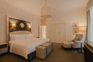a bedroom with a large white bed and a chair at Hotel Bristol, A Luxury Collection Hotel, Warsaw in Warsaw