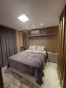 ein Schlafzimmer mit einem großen Bett in einem Zimmer in der Unterkunft Belo Apartamento no Centro de Capão da Canoa in Capão da Canoa