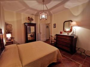 a bedroom with a bed and a dresser and a mirror at Villa Montesegnale in Bolsena