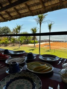 einen Tisch mit Tellern und Strandblick in der Unterkunft Beach House- KiteAliCori , Macapa' in Ponta do Anel + 8 Fotos