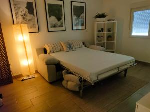 ein Bett in einem Zimmer mit einer Couch und einer Lampe in der Unterkunft El Cedro in Santa Cruz de Tenerife