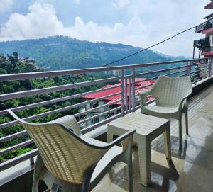 two chairs and a table on top of a balcony at Luxury home with projector room near Kasauli in Dagshai