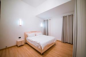 une chambre avec un lit blanc et un parquet dans l'établissement The Milon Apartment, à Kigali 27 autres photos