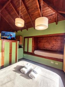 a bedroom with a bed with two towels on it at Solar de las Araucarias in San Carlos de Bariloche