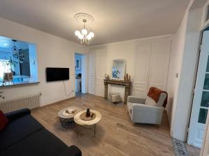 a living room with a couch and a table at Appartement Villa Les Lilas in Dunkerque