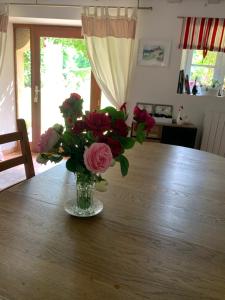 a vase of flowers sitting on a table at Chambre d'Hôtes Le Moulin des Landes in Vernou-sur-Brenne
