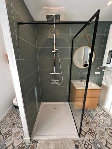 a bathroom with a shower with a sink and a mirror at Appart cosy - belle vue in Niort +7 photos