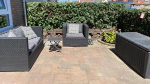 three wicker chairs and a table in a patio at At Juliette in Zandvoort