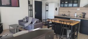 a kitchen and living room with a couch and a table at T2 vue imprenable au calme in Nice