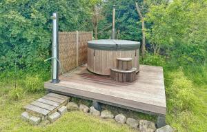 - un bain à remous installé sur une terrasse en bois dans une cour dans l'établissement Holiday Home Gyvelvænget Glesborg Ii, à Fjellerup Strand 26 autres photos